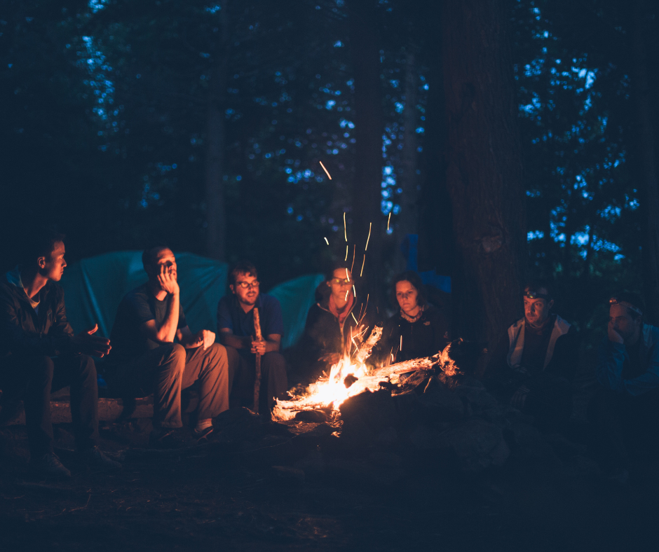 Women gathered around a fire circle in the forest